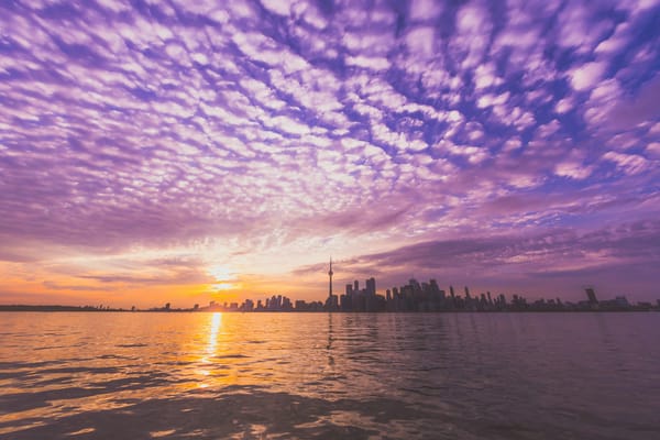Sunset of Toronto skyline from the lake with a brilliant purple sky and clouds